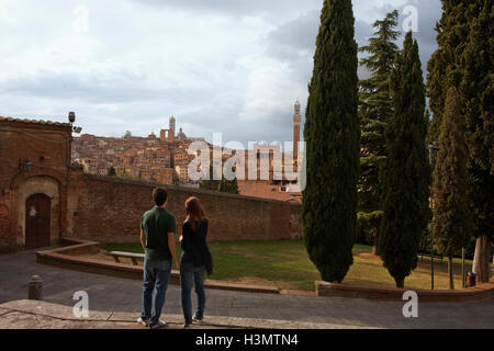 Una giovane coppia guarda il famoso skyline di Siena, Toscana, Italia Foto Stock