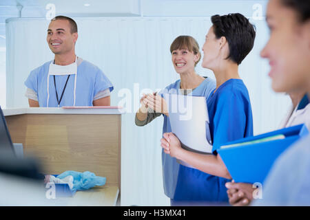 Il personale medico chat a stazione di infermieri in ospedale Foto Stock