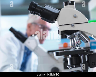 Microscopi essendo utilizzato durante un esperimento in un laboratorio Foto Stock