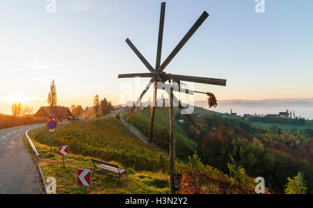 Kitzeck im Sausal (Südsteirisches Weinland): la chiesa di Maria dolorosa, vigneti, villaggio, sunrise, Klapotetz (vento ruota, utilizzato come b Foto Stock