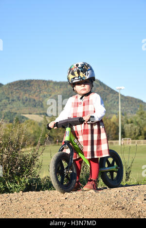 Due anni di vecchia ragazza su una bilancia bike Foto Stock