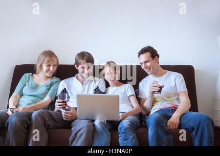 Gruppo di amici a ridere con il computer portatile Foto Stock