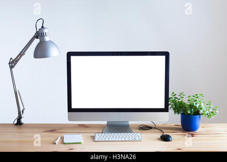 Ufficio moderno interno con computer, tavolo in legno, lampada da lavoro e pianta verde Foto Stock