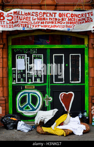 Manchester, Regno Unito. 11 ottobre, 2016. Un giovane uomo, Chris da Salford, sono saliti sul tetto del Ducie Bridge public house in Miller Street a 8-o-Orologio questa mattina in protesta per lo sfratto di 30 persone senzatetto che sono state squatting in costruzione per diverse settimane. Alta Corte i funzionari di polizia ha guadagnato l'entrata al palazzo di proprietà della società cooperativa, questa mattina di sfrattare la squatter che erano sfidando un alta corte ordine di sfratto. Credito: Dave Ellison/Alamy Live News Foto Stock