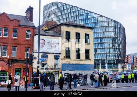 Manchester, Regno Unito. 11 ottobre, 2016. Un giovane uomo, Chris da Salford, sono saliti sul tetto del Ducie Bridge public house in Miller Street a 8-o-Orologio questa mattina in protesta per lo sfratto di 30 persone senzatetto che sono state squatting in costruzione per diverse settimane. Alta Corte i funzionari di polizia ha guadagnato l'entrata al palazzo di proprietà della società cooperativa, questa mattina di sfrattare la squatter che erano sfidando un alta corte ordine di sfratto. Credito: Dave Ellison/Alamy Live News Foto Stock