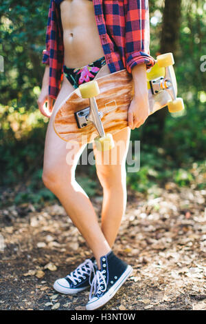 Donna con lo skateboard in posizione di parcheggio Foto Stock