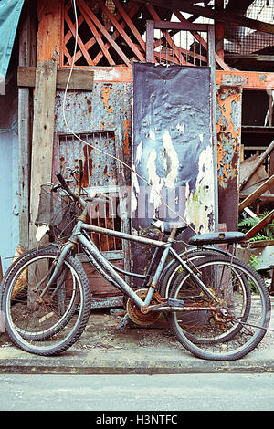 Vecchie biciclette abbandonate al di fuori di una vecchia casa in Tai O villaggio di pescatori, l'Isola di Lantau, Regione amministrativa speciale di Hong Kong Foto Stock