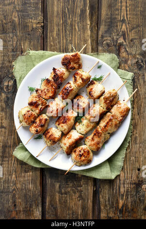 Pollo alla griglia barbecue spiedini su sfondo di legno, vista dall'alto Foto Stock