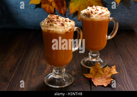 Latte macchiato di zucca con panna montata e cannella in bicchieri Foto Stock