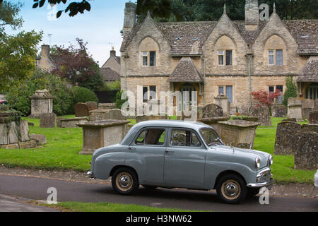 Standard di Austin classico auto parcheggiate fuori Holloways gli ospizi di carità, la chiesa di Santa Maria di Witney, Cotswolds, England, Regno Unito Foto Stock