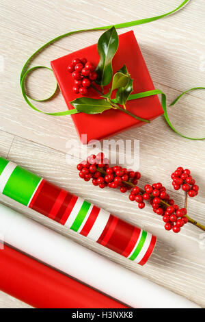 Rosso e verde di Natale la confezione regalo alimenta la carta di avvolgimento, scatola regalo, presente, nastri e botanico naturale holly bacche Foto Stock