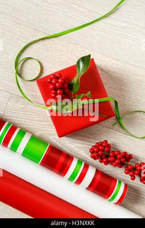 Rosso e verde di Natale la confezione regalo alimenta la carta di avvolgimento, scatola regalo, presente, nastri e botanico naturale holly bacche Foto Stock