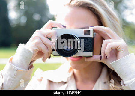 Giovane donna prendendo foto con vecchie foto fotocamera Foto Stock