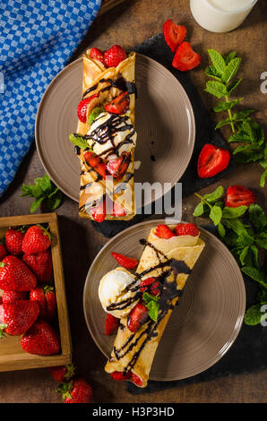 Crepes con gelato, Topping Caramel e fragole. Deliziosa casa creame caramello Foto Stock