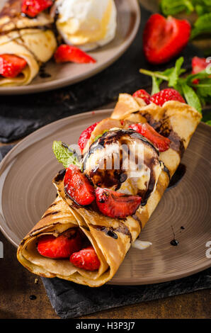 Crepes con gelato, Topping Caramel e fragole. Deliziosa casa creame caramello Foto Stock