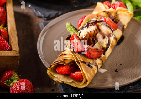 Crepes con gelato, Topping Caramel e fragole. Deliziosa casa creame caramello Foto Stock