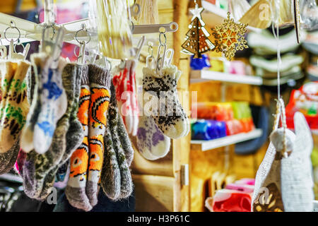 Lana calzini fatti a mano in diverse dimensioni appesi in vendita presso lo stallo durante il mercatino di Natale a Riga, Lettonia. A questo popolo di stallo può acquistare il ginocchio e calze ordinario in vari formati e stili. Foto Stock