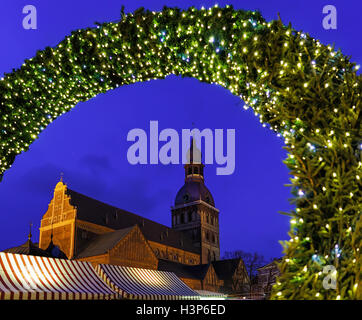 Ingresso al Mercato di Natale e Cattedrale di riga in fondo alla piazza del Duomo nel centro storico di Riga, Lettonia. La Riga o la Cattedrale del Duomo fu costruito nel 1211 dal vescovo Livonian Albert di Riga. Foto Stock