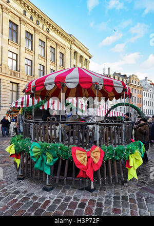 Riga, Lettonia - 25 dicembre 2015: Persone a giostra a Mercatino di Natale in piazza del Duomo nel centro storico di Riga. Foto Stock