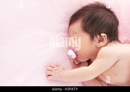 Modello rilasciato. Neonato ragazza con ciuccio in bocca. Foto Stock