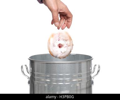 Persona di gettare la torta nel bidone della spazzatura. Foto Stock