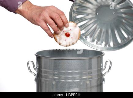 Persona di gettare la torta nel bidone della spazzatura. Foto Stock