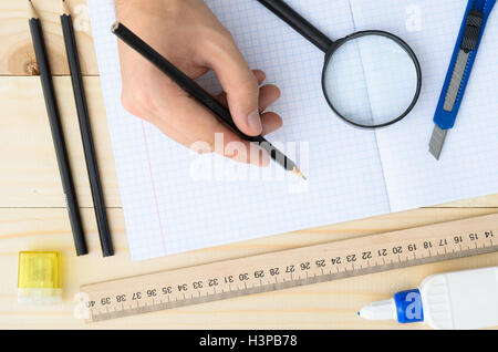 Disegnatore workplace dotato di righello, penna, cucitrice, forbici, lente di ingrandimento. Foto Stock