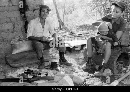 CHALATENANGO, EL SALVADOR, FEB 1984: - all'interno del FPL Guerrilla zone di controllo Evaristo, un membro della milizia PPL, pulizia la sua pistola. Foto Stock