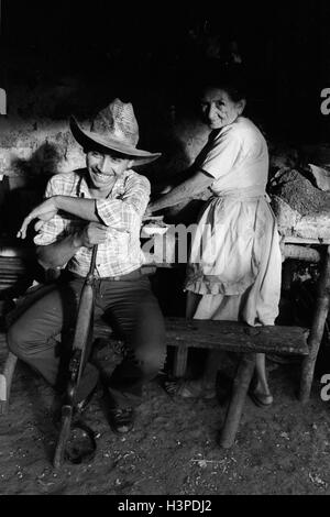 CHALATENANGO, EL SALVADOR, FEB 1984: - all'interno del FPL Guerrilla zone di controllo un membro della milizia PPL in sua madre cucina Foto Stock