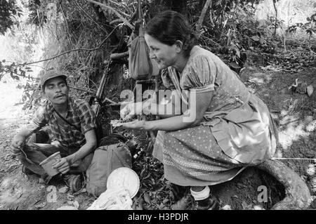 CHALATENANGO, EL SALVADOR, FEB 1984: - all'interno del FPL Guerrilla zone di controllo un membro della milizia PPL in sua madre cucina Foto Stock