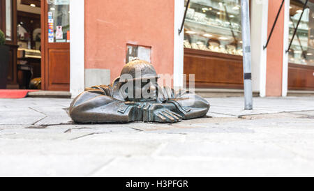 Bratislava, Slovacchia - 7 Maggio 2013: Cumil famosa statua di uomo che spuntavano da sotto un chiusino. Foto Stock