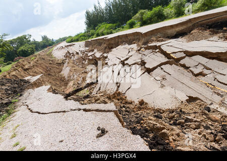 Strada asfaltata è crollato e caduto, poiché il terreno di crollare. Foto Stock