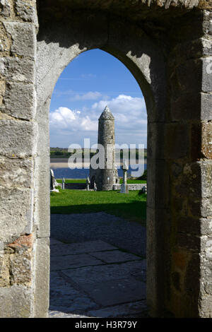 Stone round tower alto cross attraversa il monastero di Clonmacnoise insediamento monastico Offaly RM Irlanda Foto Stock