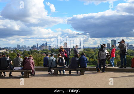 Le persone che si godono la vista dalla cima di Primrose Hill a Londra. Foto Stock