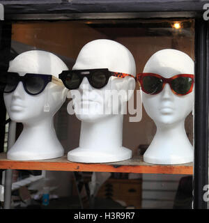 Occhiali da sole visualizzati sul manichino di polistirene capi nella vetrina di un negozio. Foto Stock