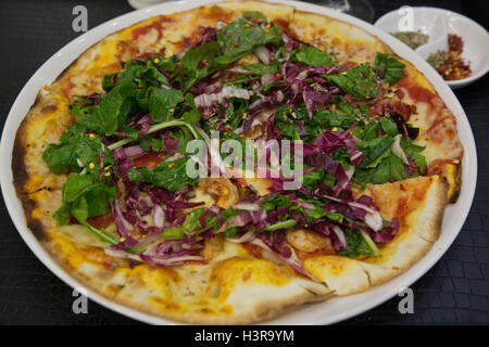 Pizza Diavola con guarnita con insalata Foto Stock