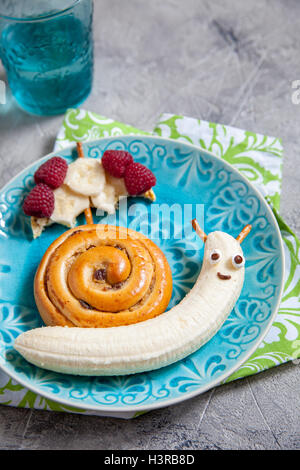 Fun food. La cannella bun con banana guardare come una lumaca Foto Stock