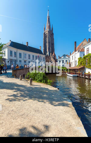 BRUGES, Belgio - Aprile 6, 2008: i turisti a piedi attraverso Dijver ponte sul canale di fronte alla chiesa di Nostra Signora Foto Stock