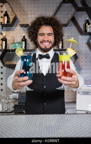 Barista tenendo due bicchiere di cocktail nel bar counter Foto Stock