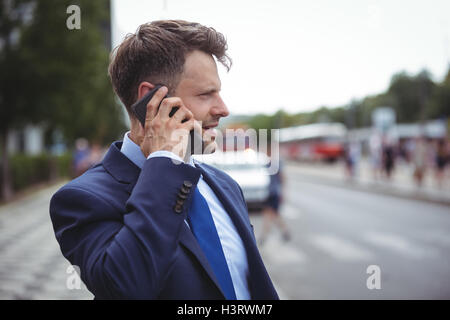 Bello imprenditore parlando al telefono cellulare Foto Stock