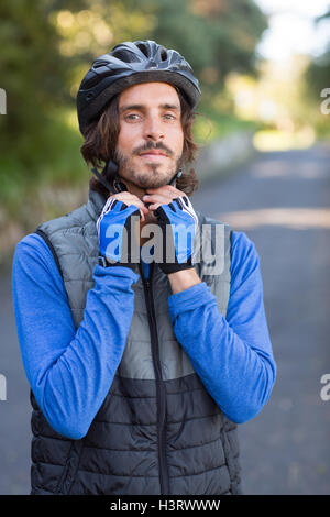 Biker maschio indossando il casco per bicicletta Foto Stock