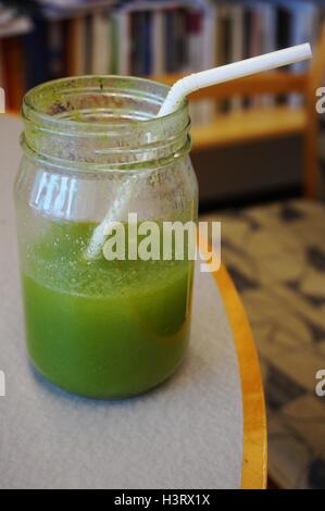 Un verde kale mojito frullati in un recipiente su una scrivania in un ufficio Foto Stock