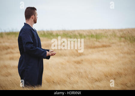 Agricoltore in piedi nel campo Cerca e visualizza Foto Stock