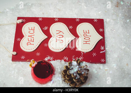 Etichetta di natale con massaggi e ornamenti natale sulla neve Foto Stock