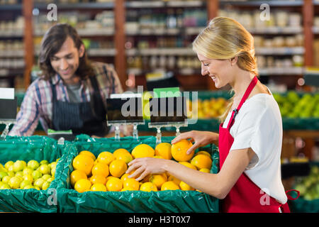 Il personale femminile controllo di frutti nella sezione biologica Foto Stock