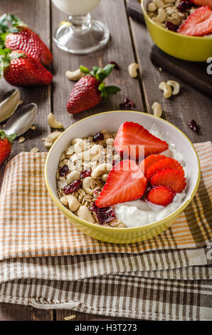 Farina di avena con yogurt fragole fresche e dadi, sana colazione ricca di vitamine Foto Stock