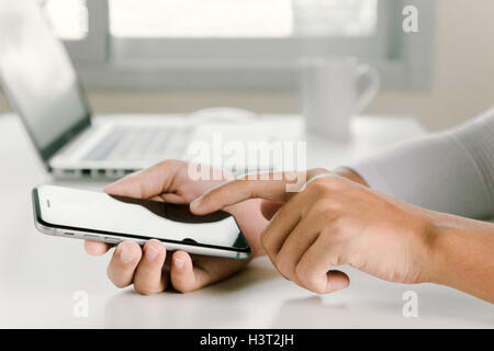 Closeup donna mano tramite telefono su spazio di lavoro in ufficio Foto Stock