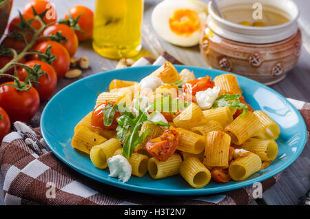 Rigatoni Pasta con mozzarella e pomodoro, erbe fresche sulla parte superiore, molto semplice e delizioso pasto Foto Stock
