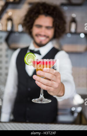 Barista tenendo un bicchiere di cocktail nel bar counter Foto Stock