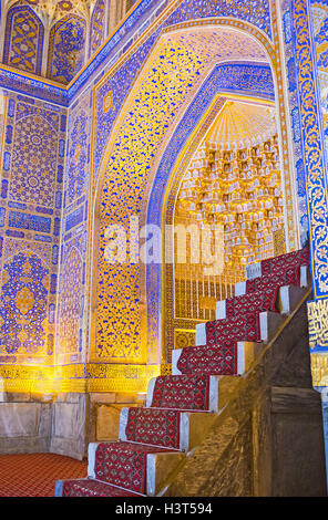 Il mihrab nella moschea di Tilya Kori Madrasah decorato con numerosi disegni dorati in Samarcanda. Foto Stock